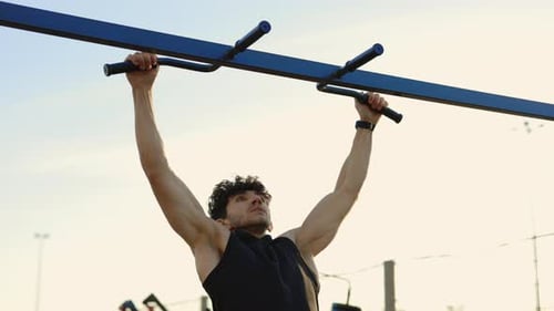Atleta apuesto y deportivo haciendo flexiones al aire libre en el patio de recreo