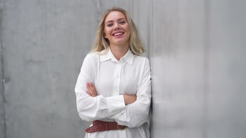 Confident Professional Woman Standing By a Grey Wall