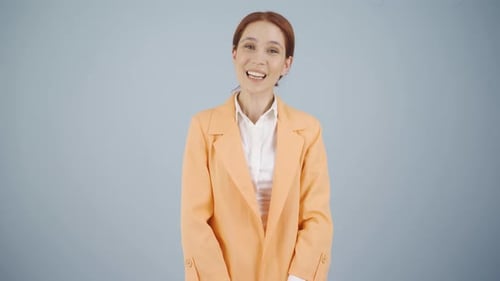 Smiling Woman in Orange Blazer Talking to Camera