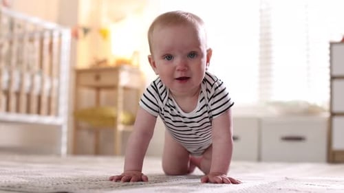 Learning to walk. Little baby crawling on floor at home