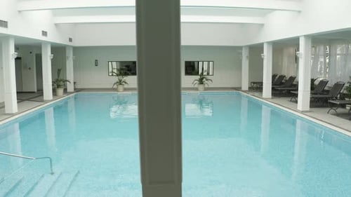 Empty Indoor Swimming Pool Of A Hotel With Lounge Chairs. - drone slider