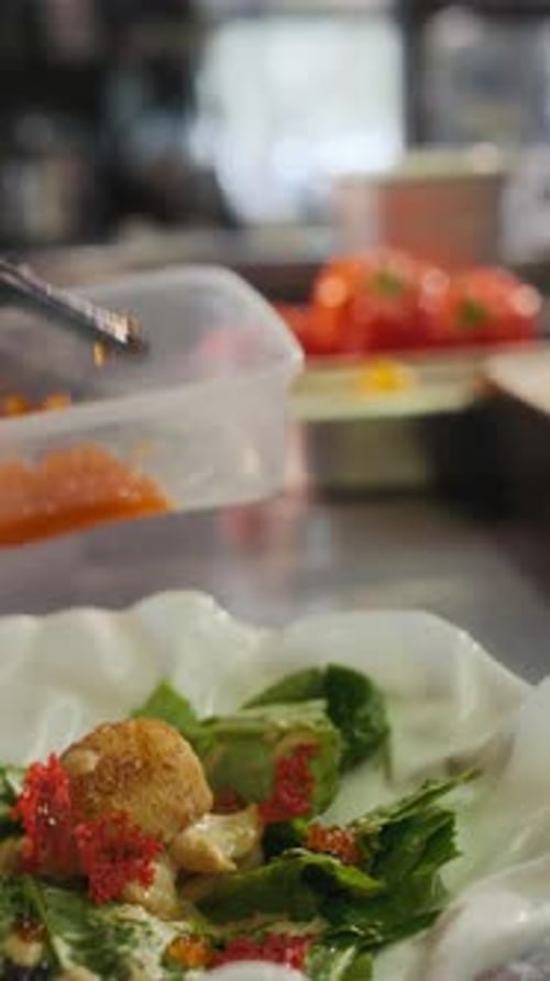Chef Preparing Salad with Fish and Roe Toppings