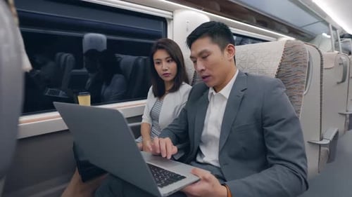 Business People Working on Laptop While Commuting by Train
