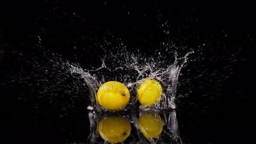 Wasserspritzer mit Zitrusfrüchten in Zeitlupe