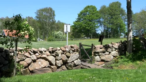 Steinmauer auf dem Land an einem schönen Tag, Schweden, breite Schusspfanne rechts