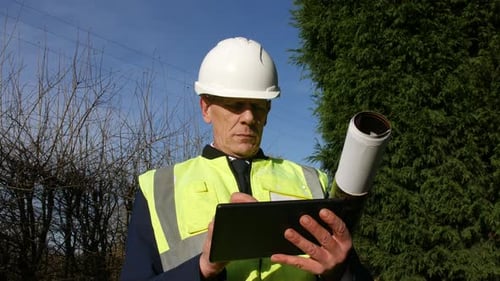 Low angle portrait of an architect building inspector inspecting a construction site with a tablet a