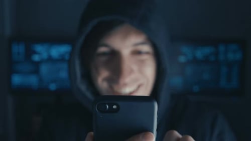 Happy Hacker in the Hood Uses a Smartphone in a Secret Data Center Filled with Screens