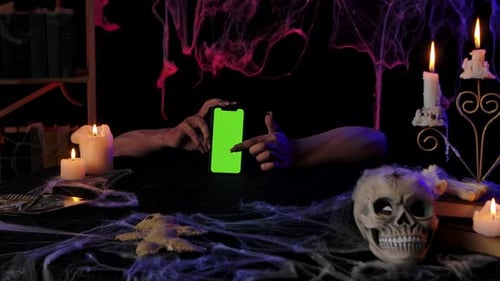 Scary Zombie Hands Hold a Smartphone with a Green Screen
