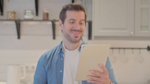 Young Man Video Calling on Tablet in Kitchen