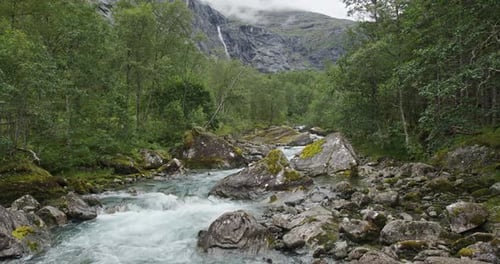 Rivière de montagne tumultueuse traversant le paysage forestier norvégien