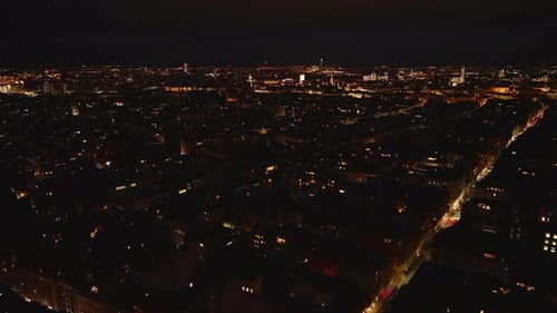 Forwards Fly Above Buildings in Urban Borough at Night Dimmed Town and Blinking Lights on High Rise