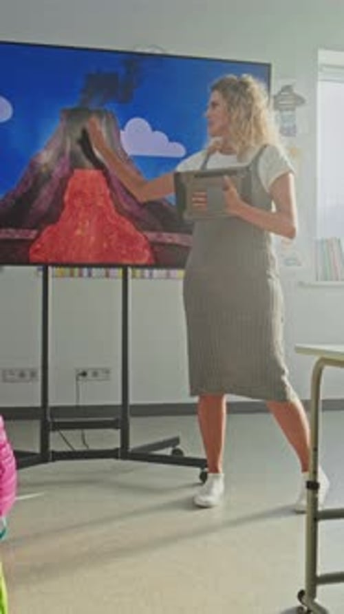 Geology Class Female Teacher with Tablet Computer Teaching Primary School Children Using Digital