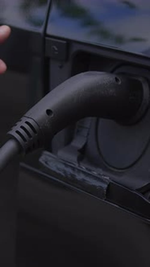 Electric Vehicle Being Unplugged From Charger