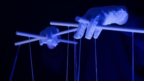 The Puppeteer Controls the Puppets in the Theater in Blue Neon Light Closeup Managing People at Work