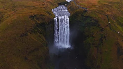 Skogafoss Waterfall Flowing Through Green Cliffs in Iceland