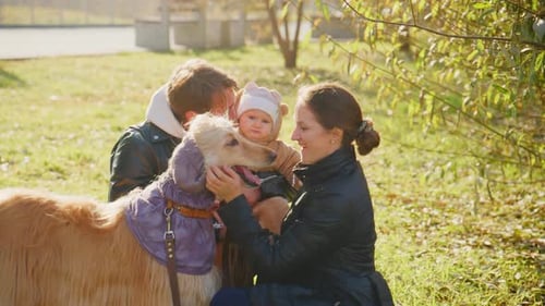 Family With Infant Enjoying Sunny Day with Dog
