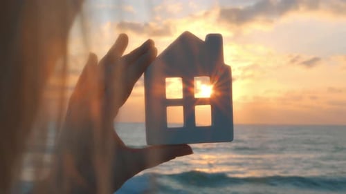 Mujer agrícola mirando la puesta de sol a través de una casa de juguetes