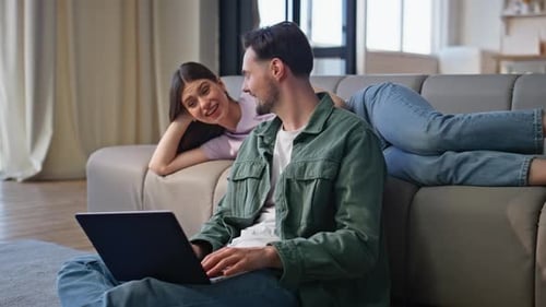 Couple Relaxing at Home Using Laptop