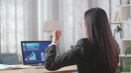 Excited Businesswoman Celebrating Success at Laptop