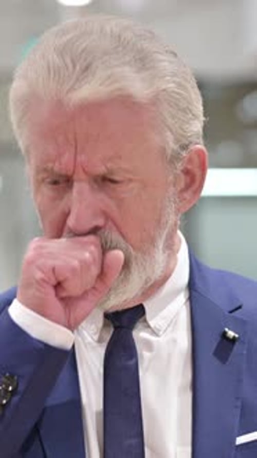 Man in Suit Coughing into Fist, Close Up