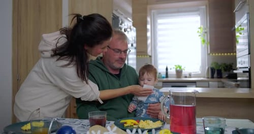 Family having breakfast with baby in modern kitchen