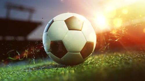 Glowing soccer ball on field at sunset