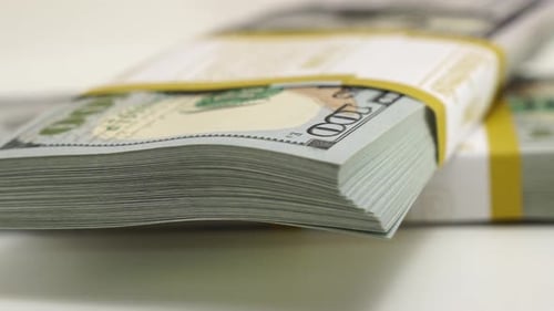Stack of Bank Bundles with US Dollars on a White Background Closeup Shot of New Freshly Printed