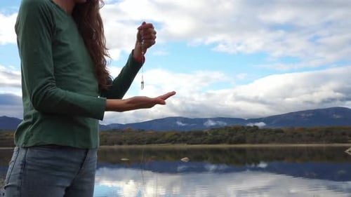 Young Woman Holding Crystal Pendulum Over Hand Outdoors