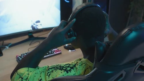 Teen Puts on Headphones to Play Video Game