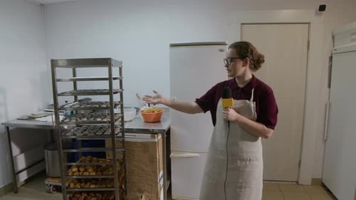 Woman Talks About Baked Goods in Commercial Kitchen