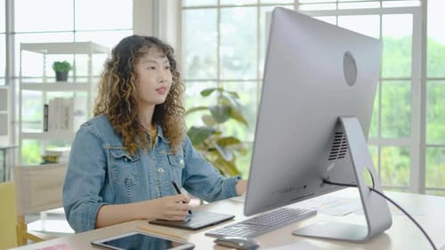 Young Woman Designs on Pen Tablet at Computer