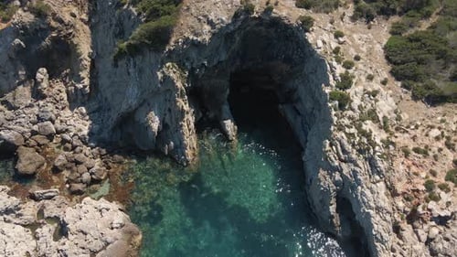Drone view of the cliffs and the beach of Ibiza, Spain. tilt down shot.