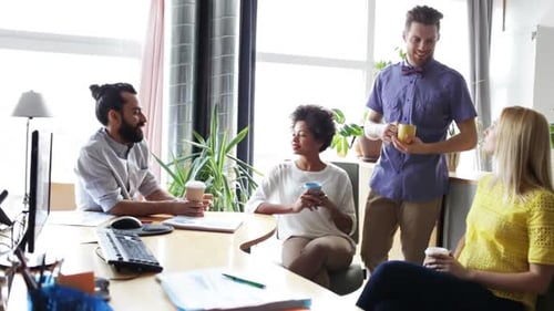 Happy multiethnic business team enjoying coffee break and discussion in office