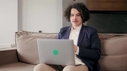 Young Adult Man Working on Laptop at Home