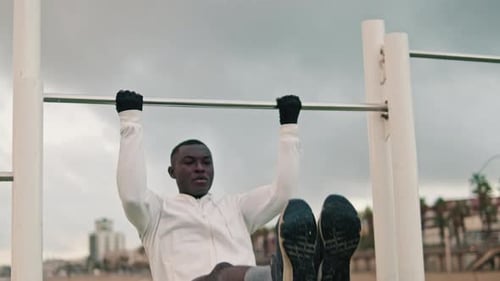 An athlete doing exercises on a bar in the open air, street workout