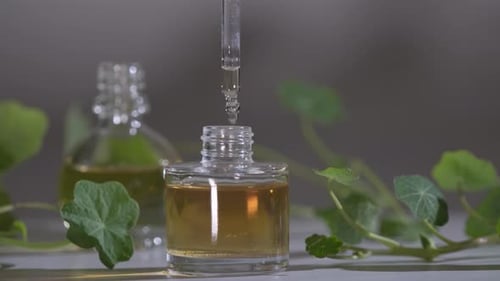 Produto de óleo essencial. Perfumaria. Gotas caindo da pipeta cosmética para o frasco de vidro com perfume