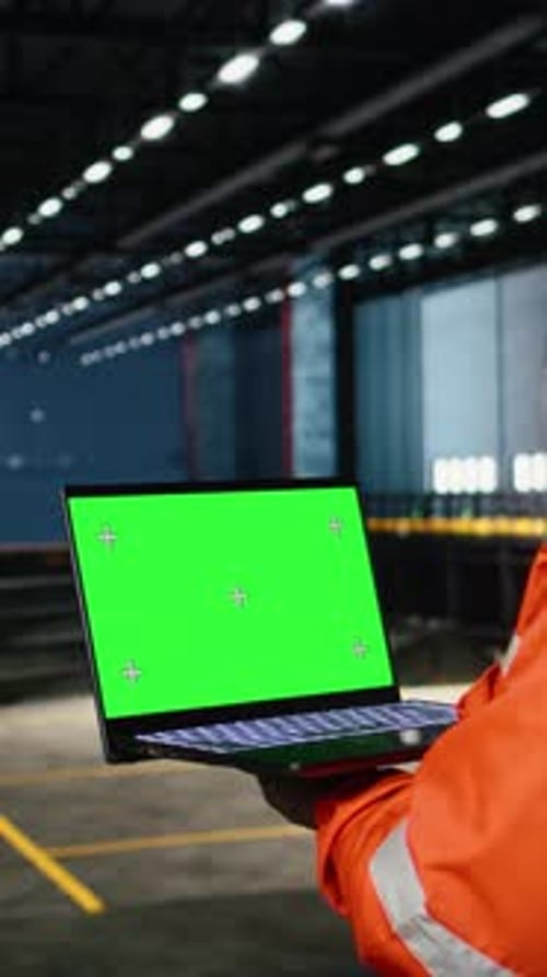 Vertical Video Green Screen Next to Operator Using Laptop and Industrial Equipment