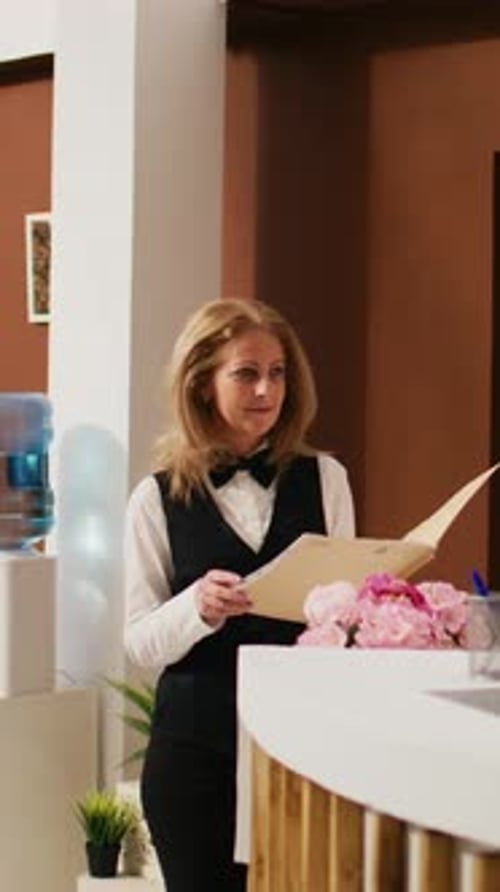 Woman in Business Attire Stands at Desk