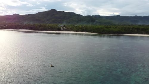 Aerial View of Surface of Water From Which Zenith Sun is Reflected Boat in Calm Sea Shore Green