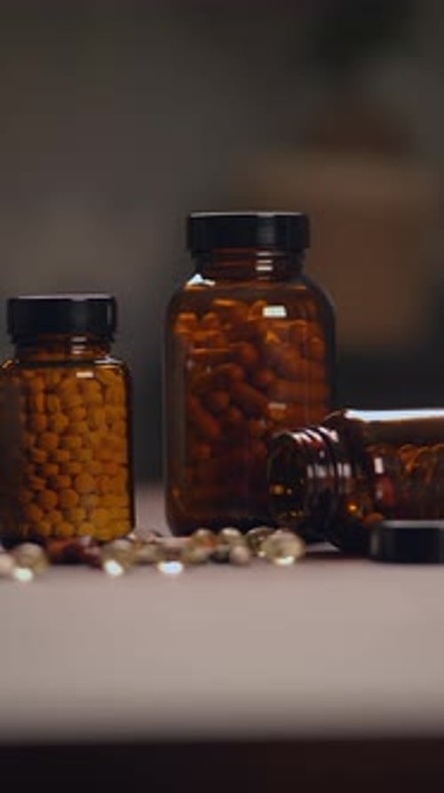 Various Bottles of Dietary Supplements Featuring Capsules and Pills Arranged on a Table Surface
