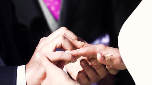 Zeitlupenaufnahme eines Bräutigams, der der Braut während der Zeremonie einen Ring an den Finger legt