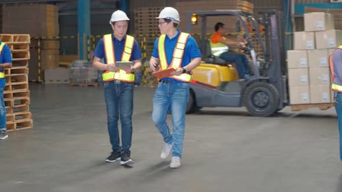 Professional warehouse manager hold document and tablet and discuss about together