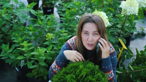 jardinier vendant des plantes par téléphone assis parmi les plantes