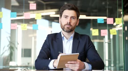 Webcam view. Male entrepreneur participates in remote meeting from workplace. Focused businessman