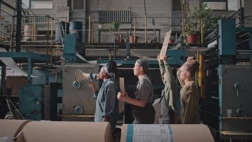 Adults Stand Together in an Industrial Factory