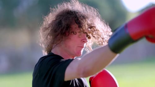 Boxer Training with Red Gloves in a Park