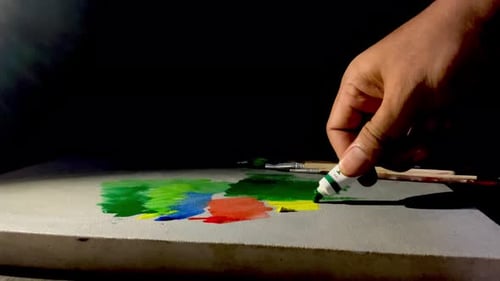 Hand Squeezing Green Paint onto Canvas
