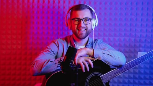 Bearded Man Smiling with Guitar in Recording Studio