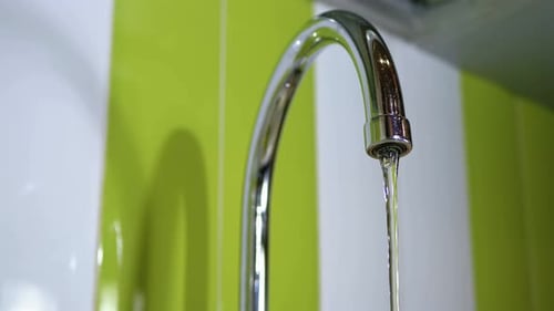 Water Dripping From the Tap Into a Sink Slow Motion