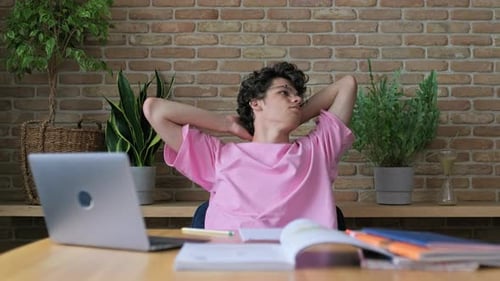 Tired Guy Student Sitting at Home at Table with Laptop Having Rest